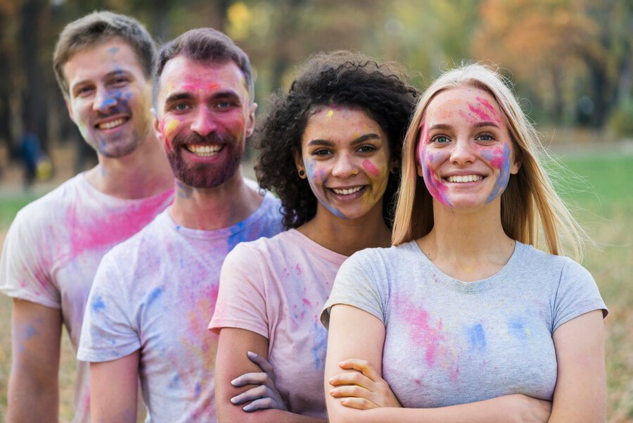 Infecciones de transmisión sexual - Grupo de personas con pintura de colores en sus rostros, sonriendo al aire libre
